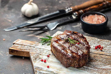 grilled beef steaks with spices on a wooden board. Restaurant menu, dieting, cookbook recipe top view