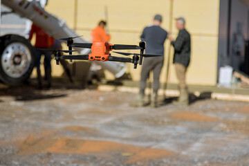On construction site an inspector monitors how concrete is being poured by employees near newly...