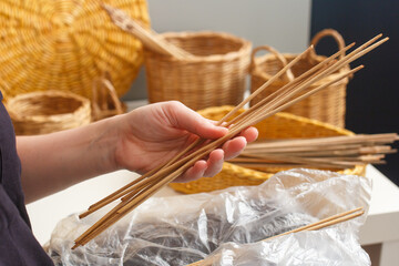 wicker weaving. Hands holding a vine for weaving