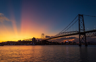 Fototapeta na wymiar raios coloridos no céu ocasionados pelo pôr do sol ponte Hercílio luz de Florianopolis Santa Catarina Brasil Florianópolis