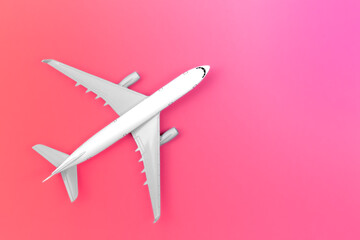 Airplane on a pink background, flat lay, travel concept.