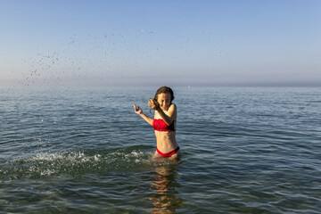 Young woman model in bikini plays with water in summer sea. Splashing water, Meme base, Holyday 