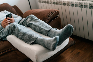 man leaning his legs on a leg man leans his legs on a leg elevation pillow pillow - obrazy, fototapety, plakaty