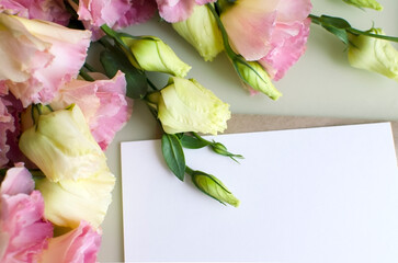 A branch of eustoma flower and a letter lies on the table