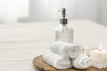 Spa composition with towels, candle and soap dispenser.