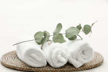 Fototapeta na wymiar Spa composition with white towels and a sprig of eucalyptus.