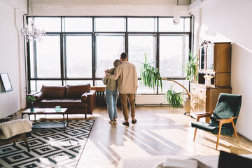 Faceless couple standing and looking outside view