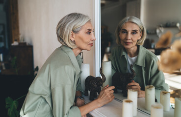 Senior woman looking at camera through mirror