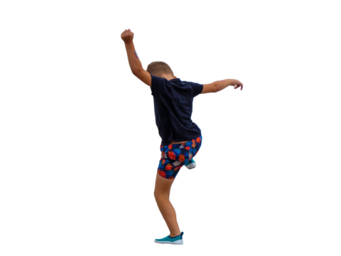 Vue de dos d’un jeune garçon qui s'amuse en sautant en été, vêtu d’un t-shirt bleu marine et d’un short coloré, geste dynamique et joyeux lors d’un moment de jeu en plein air