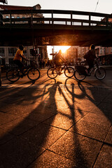 Berlin, people cycling city urban scene silhouette at sunset