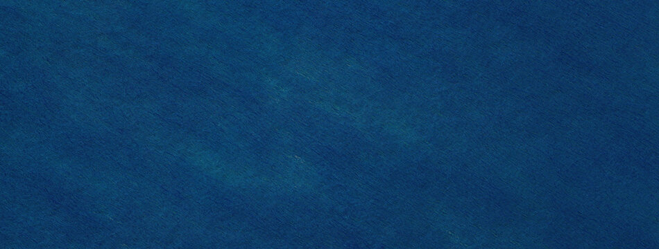 Texture of a navy blue felt background with denim spots of fabric, macro. Structure of woolen ultramarine textile