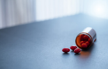 Red capsule pills and brown plastic drug bottle. Codeine and guaifenesin capsule pills to relieve...