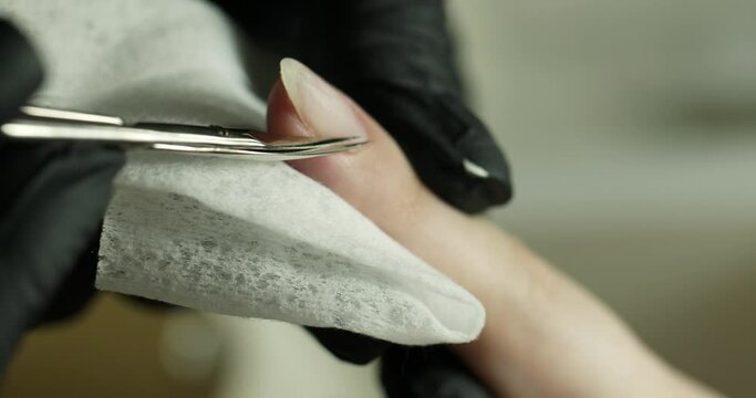 cutting the cuticle with scissors near the nail skin. manicure in the salon. macro. vertical video