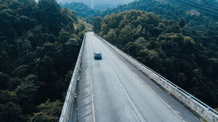 Car moving on the elevated road across the rainforest mountains in Hulu Selangor, Malaysia.