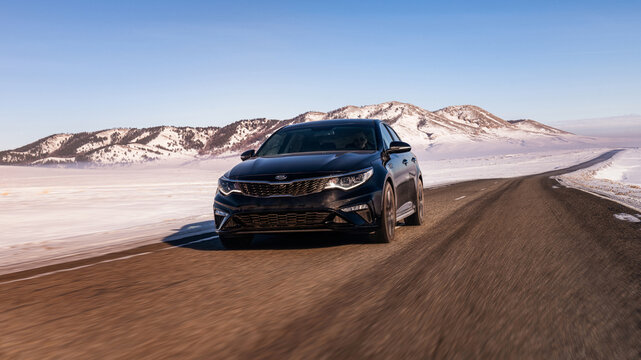 Fishhook, Alaska/USA - Feb 18, 2023: Black Kia Optima snowy mountains on the track