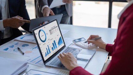 Team of business investment consultant analyzing company annual financial report working with documents pie and donut chart, using laptop and tablet, Business and Financial concept