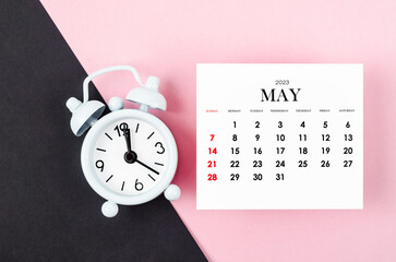 The May 2023 Monthly calendar year with alarm clock on pink and black colour background.