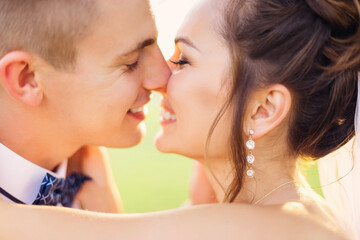 Cute young newlywed couple standing in the park kissing after the ceremony on a walk