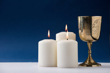 beautiful christian chalice with three candles and blue background