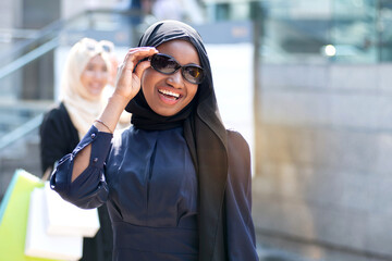 Fototapeta premium Multiethnic Muslim friends traveling and shopping at Sunday market, Lifestyle of Muslim women in hijab shopping together on weekends