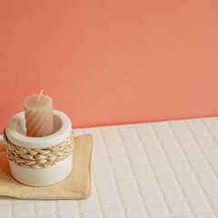 Candle holder on white table. pink wall background. cozy home decor