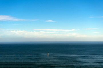 A lonely sailing boat in the ocean, seascape. Spain, Basque Country