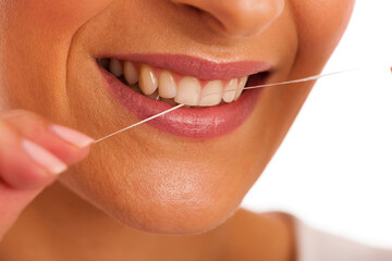Woman cleaning teeth with dental floss for perfect hygiene and healthy teeth.