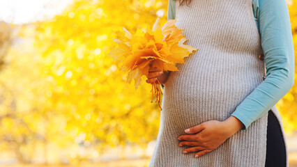 Baby expectation. Pregnant woman outdoors in autumn. Woman having happy pregnancy time.