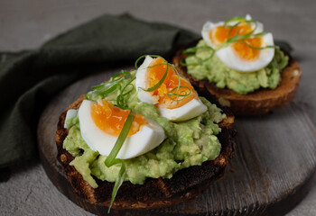 two sandwiches on toasted bread with avocado and egg, selective focus