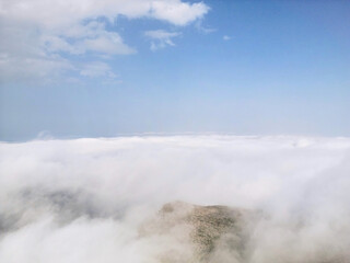 Flying above the clouds on drone.Drone soars through thick clouds, revealing majestic mountain silhouettes. Calp, Alicante, Spain
