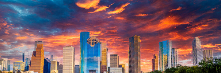 Houston Texas downtown buildings and city skyline, panoramic metropolis landscape with dramatic clouds over the public park at sunset