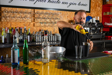 hombre barman con gorro de vaquero preparando un cóctel azul en la barra del bar