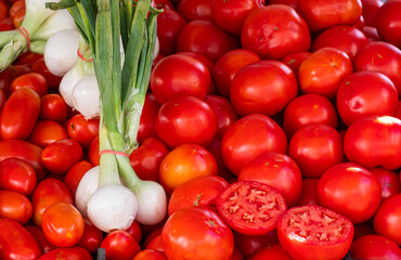 Spring Onions also known as Salad Onions, Scallions tomatoes and onions at a street stall in a local market