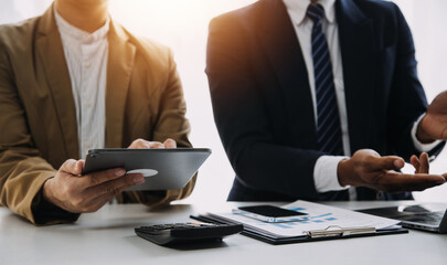 Financial analysts analyze business financial reports on a digital tablet planning investment...