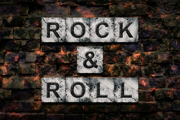 Rock and Roll. Words on stone blocks, on old vintage bricks wall. Direction in music. Musical style. Design
