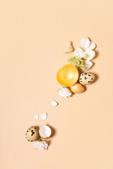Monochrome flat lay Easter eggs composition decoration with twigs and flowers. Easter still life beige