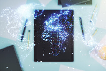 Abstract creative world map and modern digital tablet on background, top view, international trading concept. Multiexposure