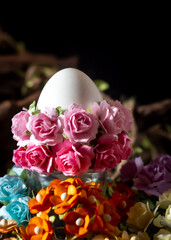Easter egg and flowers on a black background. Easter concept.