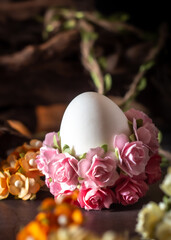 Easter egg decorated with pink flowers on a wooden background. Selective focus