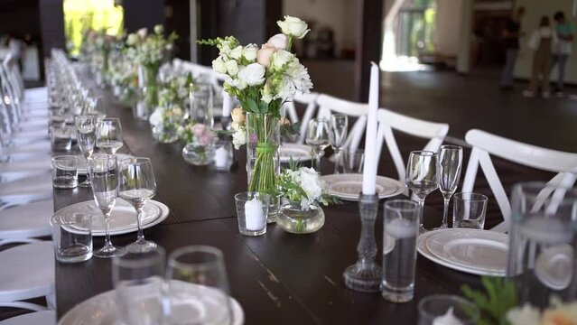 A very nicely decorated wedding table appointments with beautiful decor with plates and serviettes in spring garden. Beautiful flowers on table in wedding day. The elegant dinner table. Wedding day
