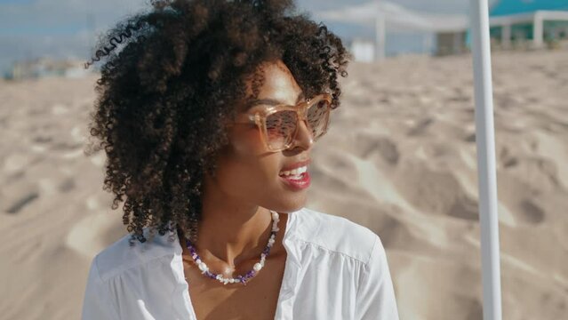 Stylish woman enjoying beach on sunny day closeup. Happy african american girl 