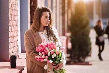 Fototapeta premium Beautiful girl with tulip flowers in her hands 
