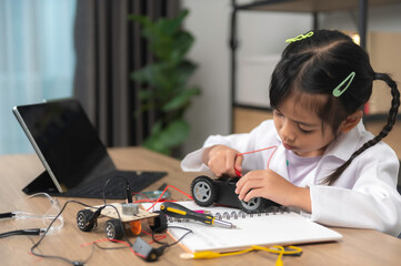 Asian littlle girl constructing and coding robot at STEM class,Fixing and repair mechanic toy car