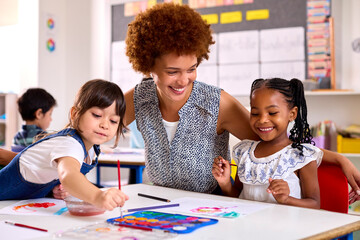 Female Teacher With Multi-Cultural Elementary School Pupils In Art Class At School
