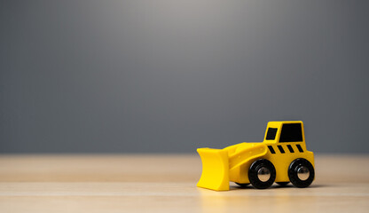 The yellow bulldozer toy. Construction works. Clearing and leveling the land. Building destruction....
