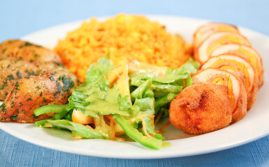 chicken, rice with peas, salad and baked potatoes