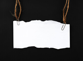 blank ripped paper hanging on rope