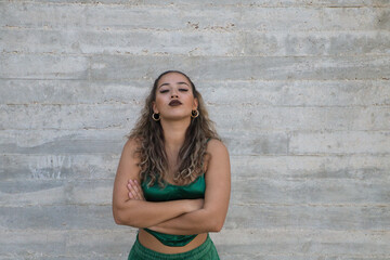 Portrait of Latin woman, young and beautiful dancing modern dance on a gray cement background on the street making different expressions and postures. Concept dance, art, action, beauty, youth art.