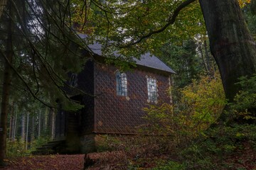 A little wooden chapel in the dark autumn forest near Neratov, Czech republic