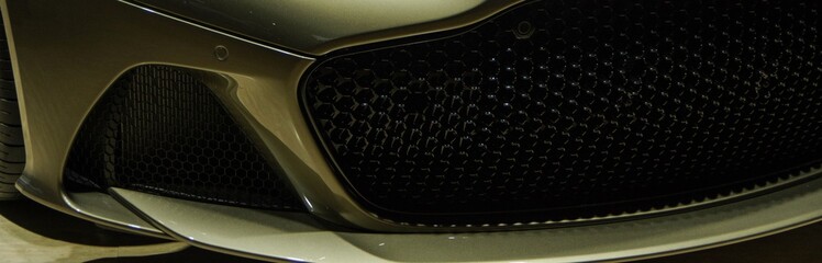 luxury beige golden color sports car front grille and bumper spiltter lip close up view banner